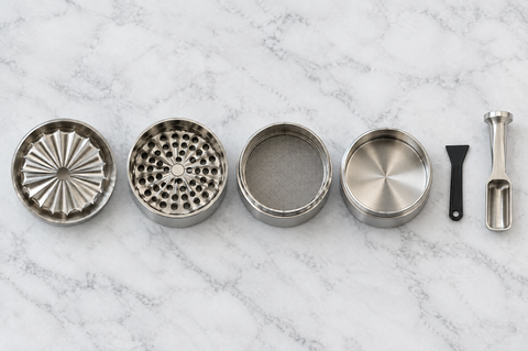 Alle Teile des HIZEN Edelstahl Grinders: Deckel mit Wellen-Mahlwerk, Mahlkammer, Pollensieb, Pollenkammer, Pollenschaber und Dosierlöffel
